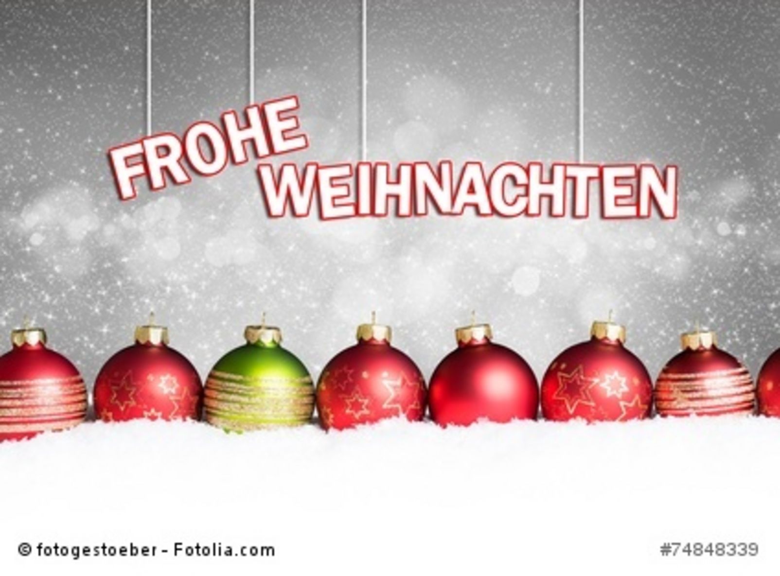 Weihnachtskugeln im Schnee vor weihnachtlichem Hintergrund